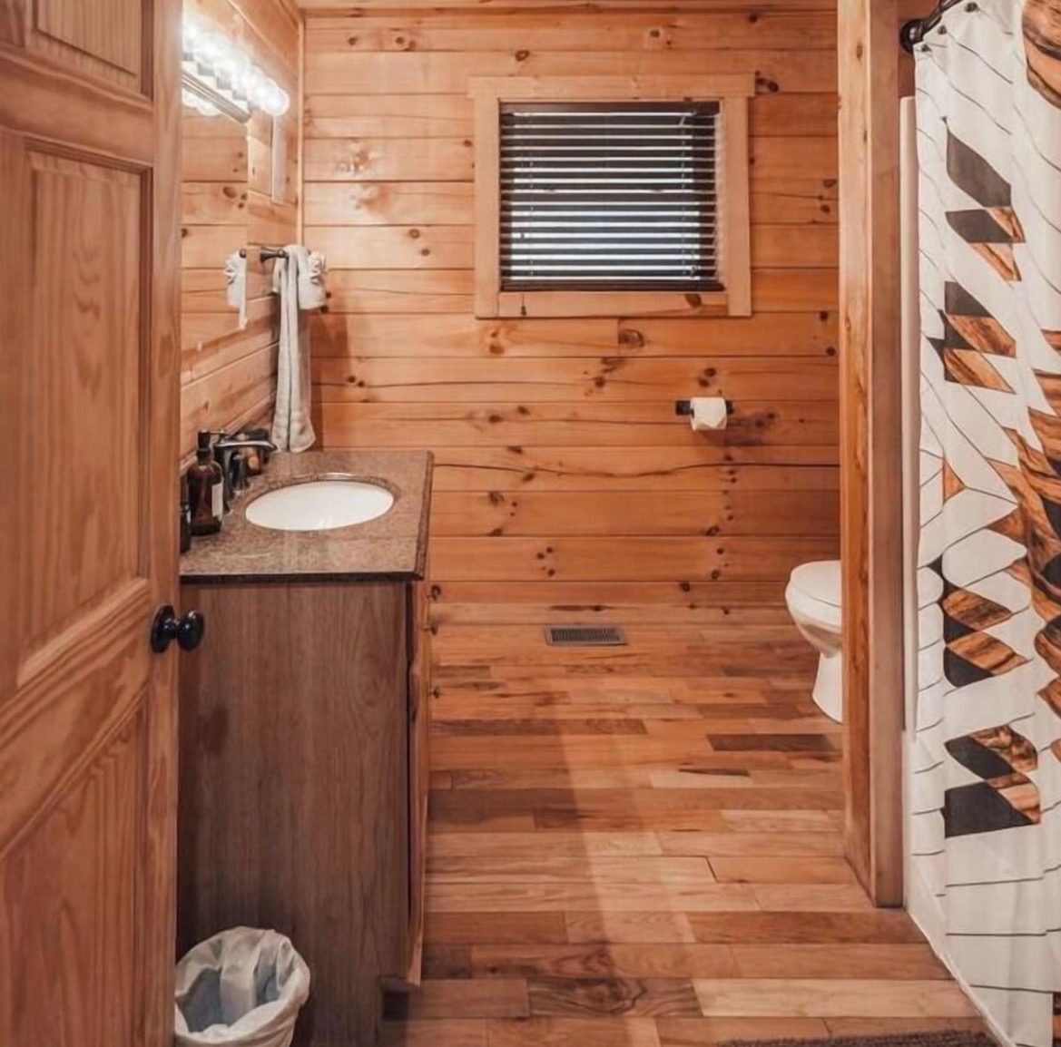 Bathroom with tub/shower combo and wood-paneled walls