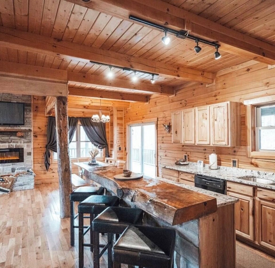 Kitchen with a live-edge wood island, bar stools and granite counters