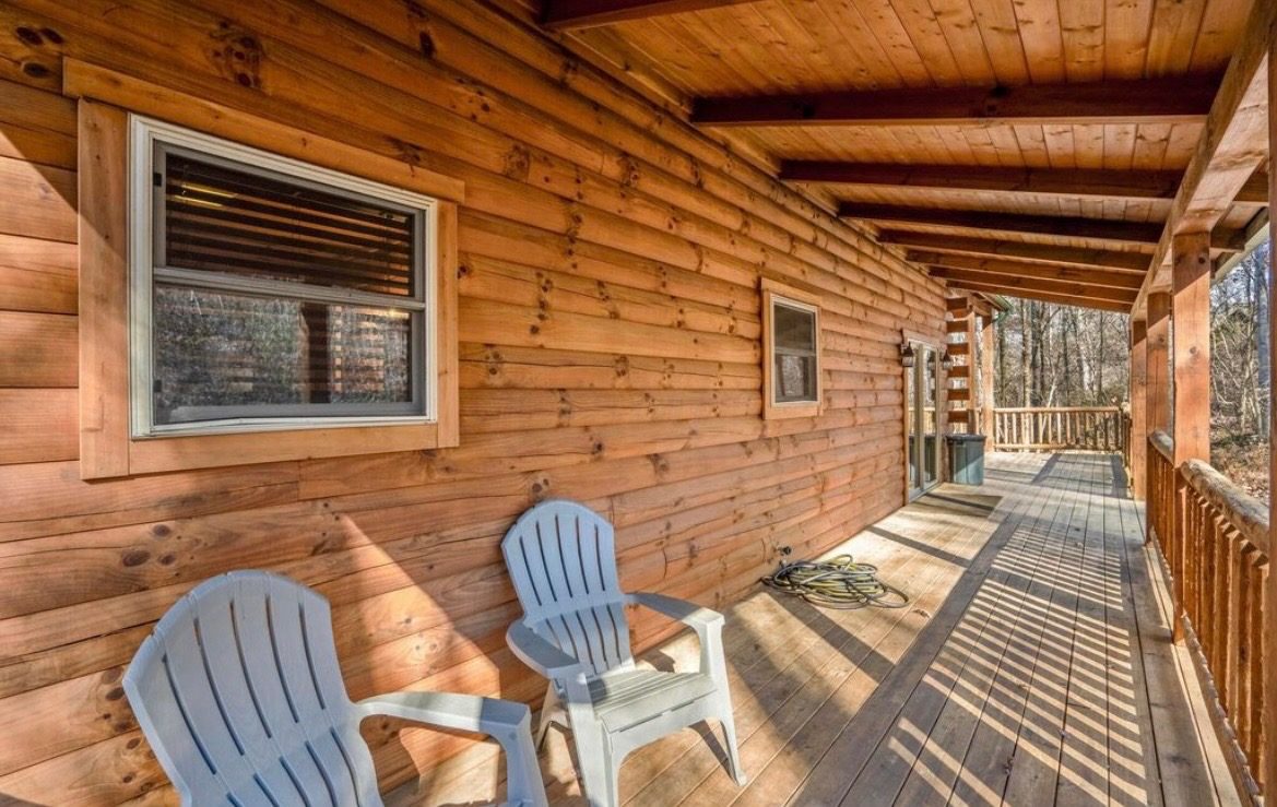 Long covered porch with two Adirondack chairs