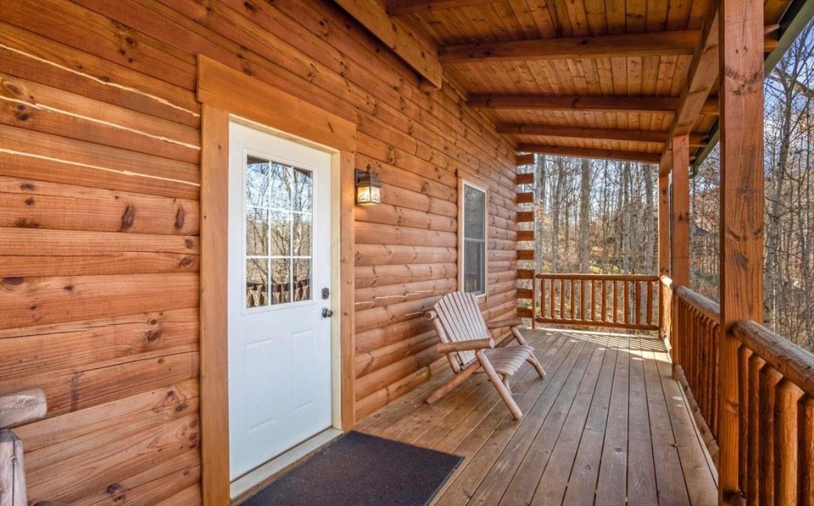 Covered front porch with log siding and a log chair