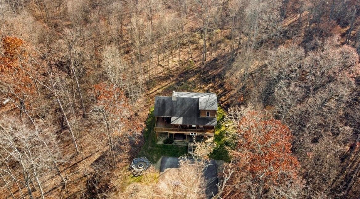 Aerial view of the lodge and fire pit among autumn trees