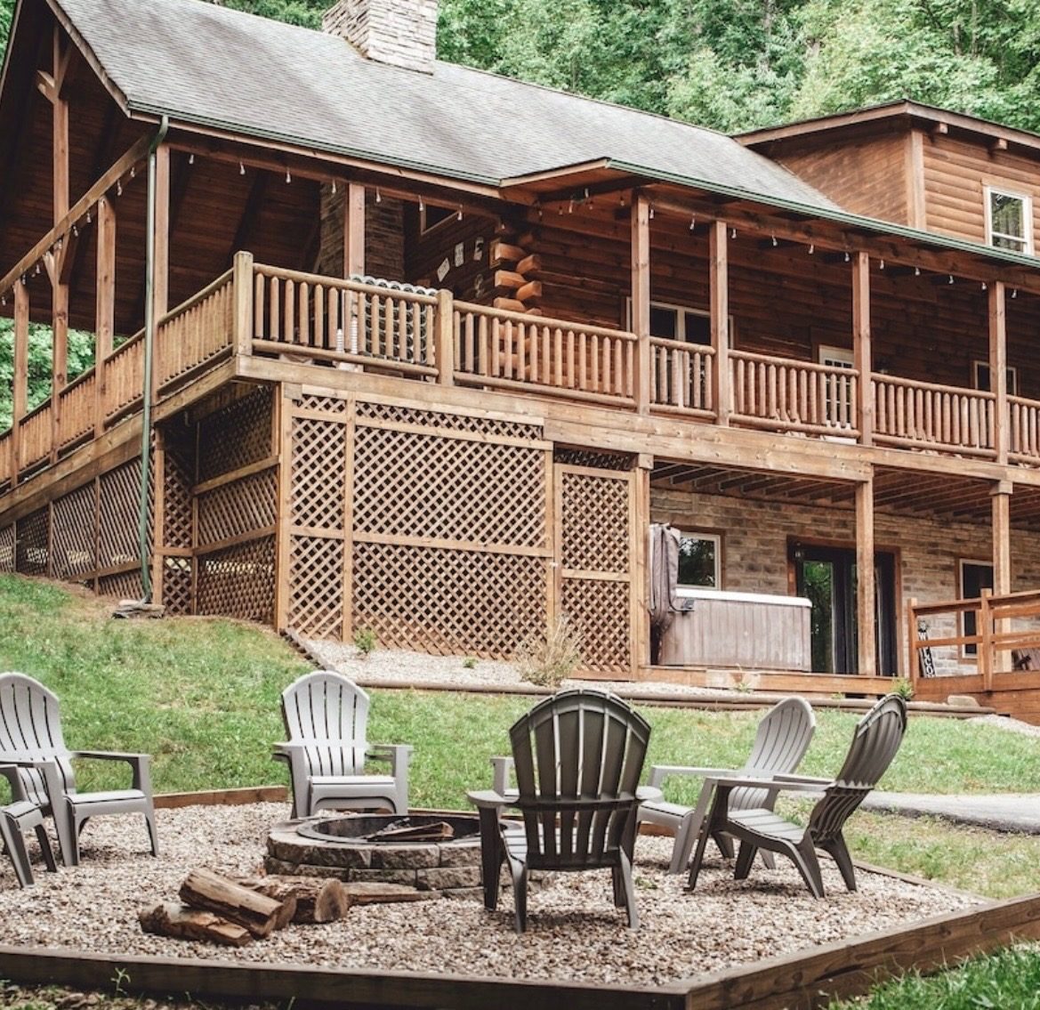 Back of the lodge seen from the gravel fire pit with Adirondack chairs