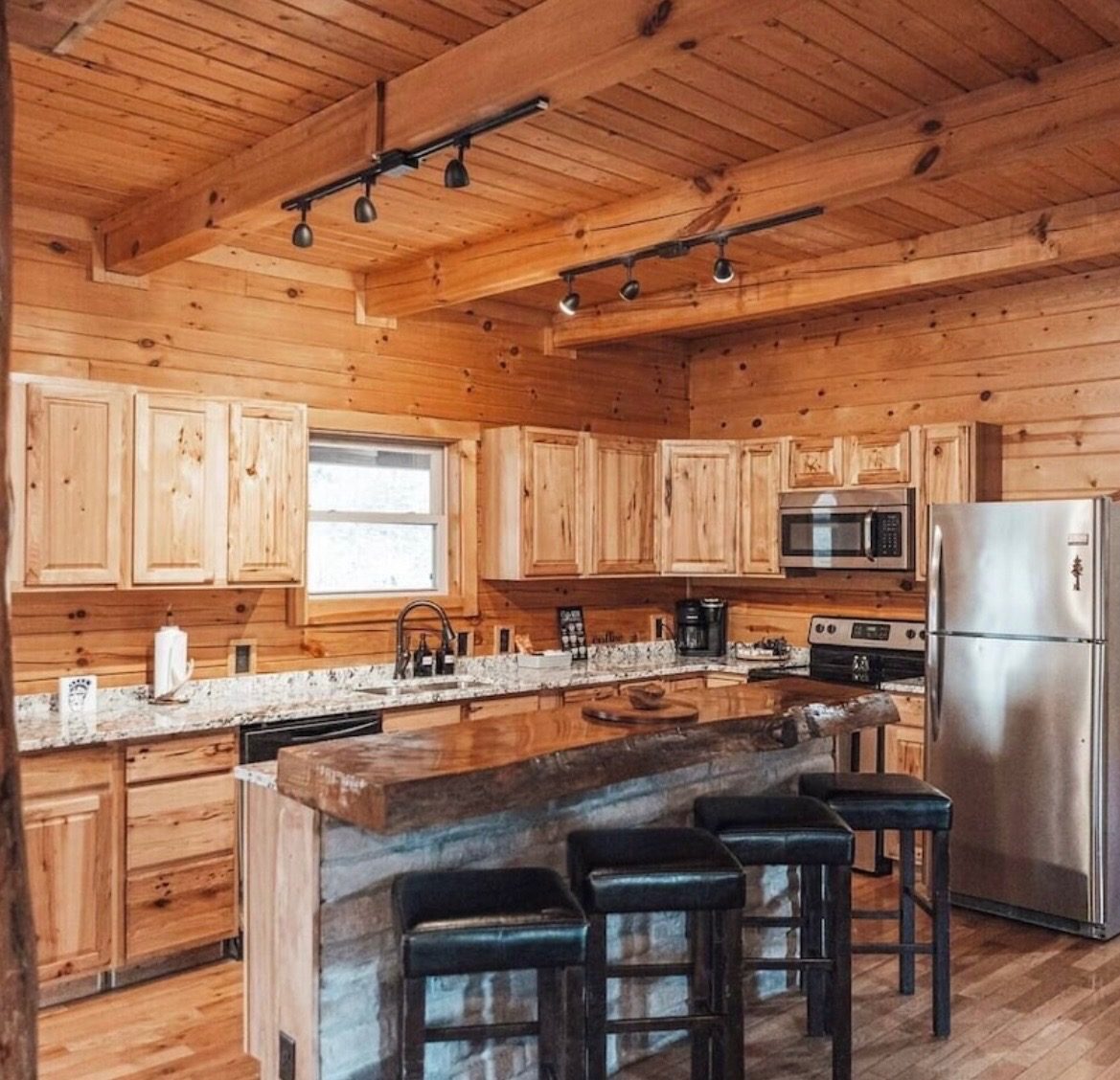 Kitchen with stainless steel appliances and a center island with bar stools